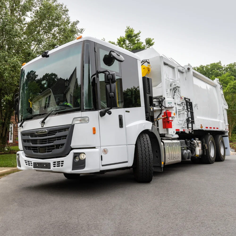 Freightliner refuse truck close-up in residential setting